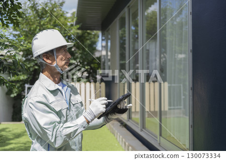 房屋檢查圖片:一名資深工人拿著平板電腦檢查房屋 房屋檢查圖片:一名資深工人拿著平板電腦檢查房屋 130073334