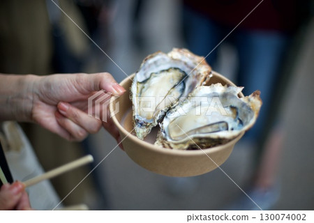 Takeaway grilled oysters bought to eat while walking around Takeaway grilled oysters bought to eat while walking around 130074002