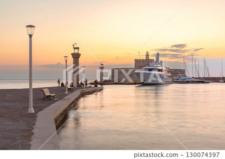 Mandraki Harbour in Rhodes, Greece at sunset 130074397