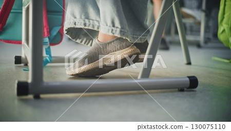 Close Up Shot of Young Student Sitting at the Desk, Picking Up Fallen Marker From the Floor 130075110