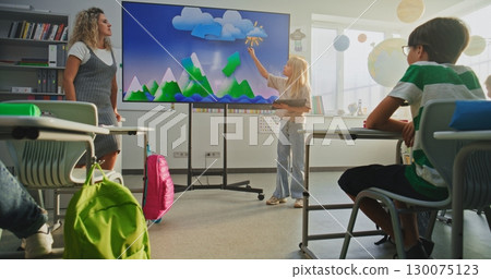 Primary School Girl Showcasing Knowledge of Geography in Front of Class and Teacher Using Digital Screen 130075123