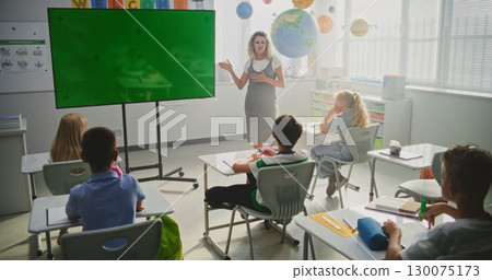 Female Teacher Educating Elementary School Students. Large Digital Screen with Chroma Key 130075173