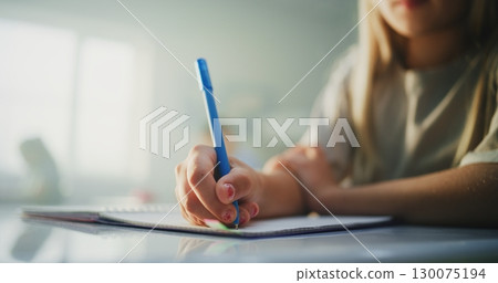 Close Up Shot of Young Girl Writing Exam, Doing Task or Drawing in Notebook Close Up Shot of Young Girl Writing Exam, Doing Task or Drawing in Notebook 130075194