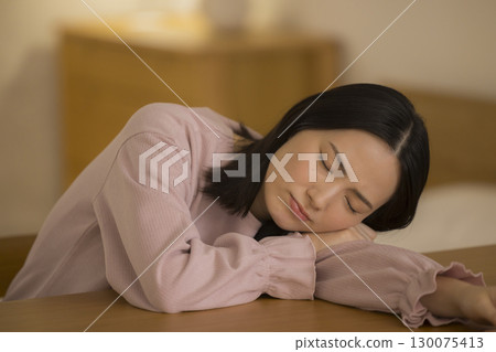 晚上在客廳睡覺的年輕女子 晚上在客廳睡覺的年輕女子 130075413