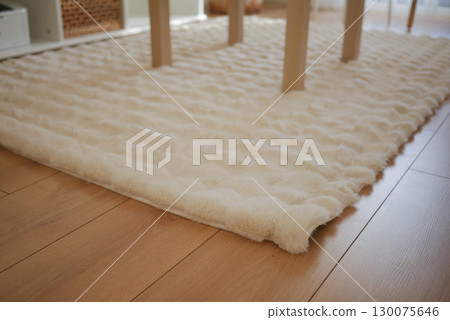 Cozy textured rug under a dining table in a bright room Cozy textured rug under a dining table in a bright room 130075646