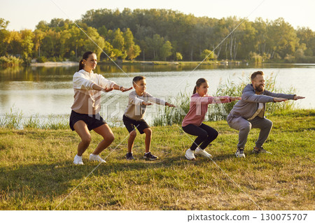Young family with two children is playing sports outside on bright sunny day. 130075707