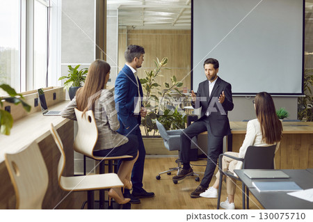 Team of business people discussing something during a work meeting in the office 130075710