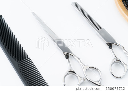 Close-up of a set of haircutting scissors, thinning shears and a comb 130075712