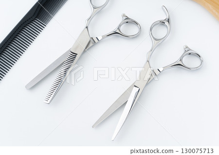Close-up of a set of haircutting scissors, thinning shears and a comb 130075713
