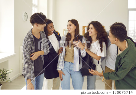 Group of happy diverse teenage boys and girls communicating and having fun at school  130075714