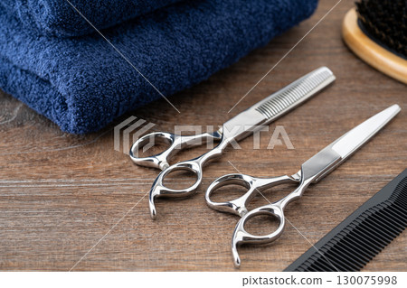 Close-up of a set of haircutting scissors, thinning shears, comb and hairbrush Close-up of a set of haircutting scissors, thinning shears, comb and hairbrush 130075998