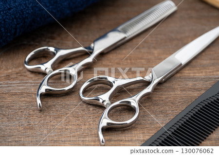Close-up of a set of haircutting scissors, thinning shears and a comb 130076062