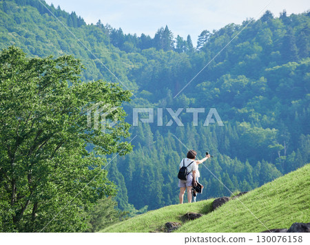 Tourists strolling along the Shogawa River in Shirakawa-go, a popular tourist spot 130076158