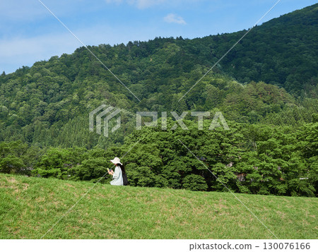 Tourists strolling along the Shogawa River in Shirakawa-go, a popular tourist spot Tourists strolling along the Shogawa River in Shirakawa-go, a popular tourist spot 130076166