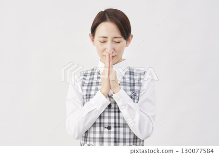 Female office worker praying with hands together in prayer on white background 130077584