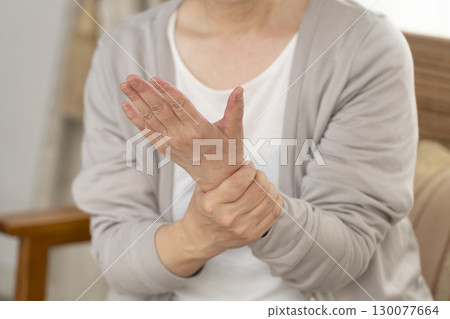Senior woman's hands suffering from pain and stiffness 130077664