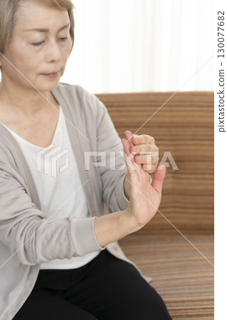 Senior woman's hands suffering from pain and stiffness 130077682