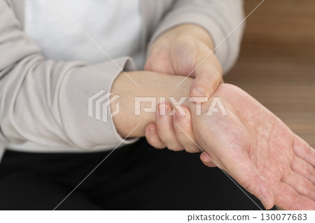 Senior woman's hands suffering from pain and stiffness 130077683