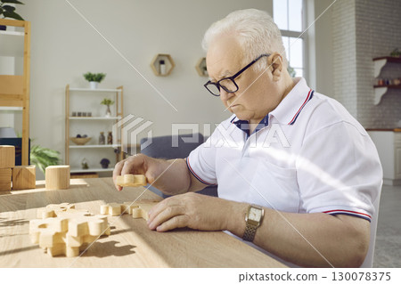 Senior man playing with jigsaw puzzle to prevent dementia and Alzheimer's disease Senior man playing with jigsaw puzzle to prevent dementia and Alzheimer's disease 130078375