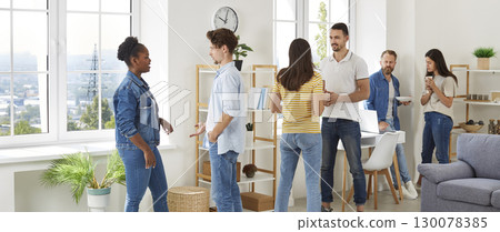 Multiracial group of friends people enjoying home party with snacks and drinks 130078385