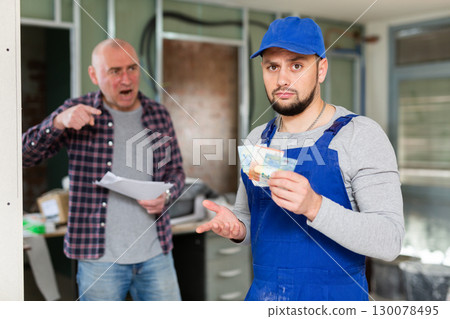 Puzzled young builder upset with small salary at construction site 130078495