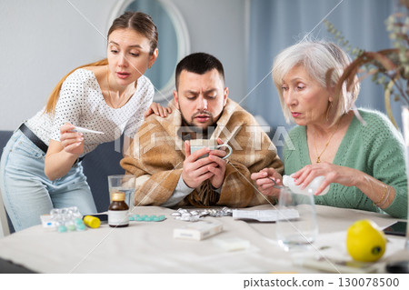 Wife and mother-in-law taking care of ill man Wife and mother-in-law taking care of ill man 130078500