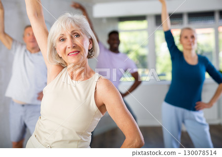 Mature men and women practicing Rock 'n' Roll dance in training hall Mature men and women practicing Rock 'n' Roll dance in training hall 130078514