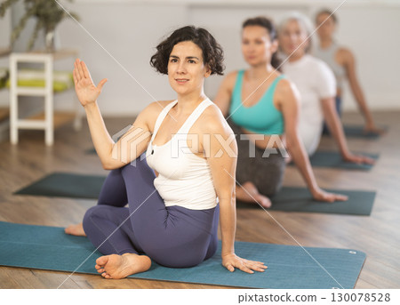 Group of women of different ages working out practice Lord of fishes pose Group of women of different ages working out practice Lord of fishes pose 130078528