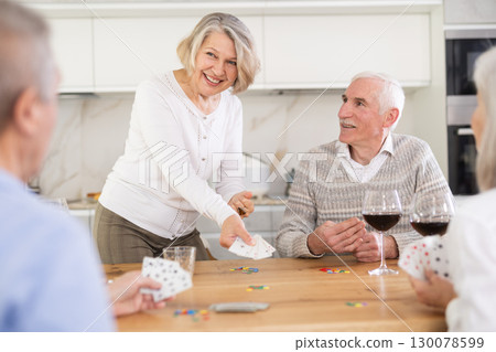 Group of friends playing poker cards and drinking wine at home 130078599