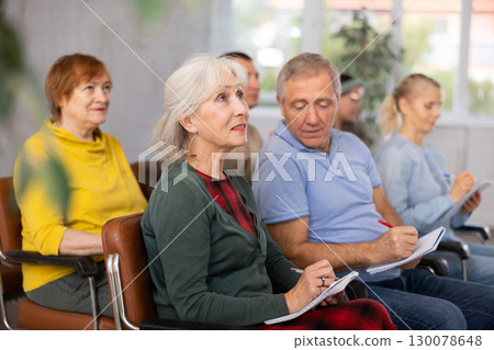 Interested elderly woman listening lesson during language courses 130078648