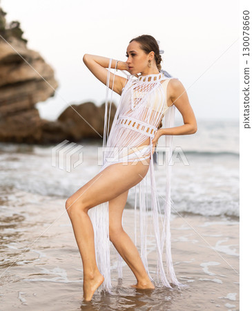Barefoot girl on seashore in sexy and revealing Amazon tribe carnival costume. 130078660