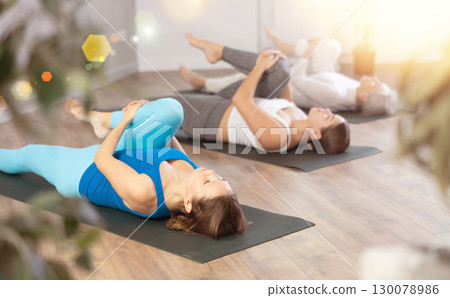 Adult woman doing yoga in fitness studio Adult woman doing yoga in fitness studio 130078986