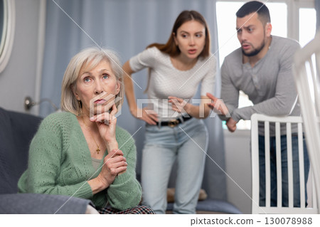 Chagrined senior woman having problems in relationship with couple Chagrined senior woman having problems in relationship with couple 130078988