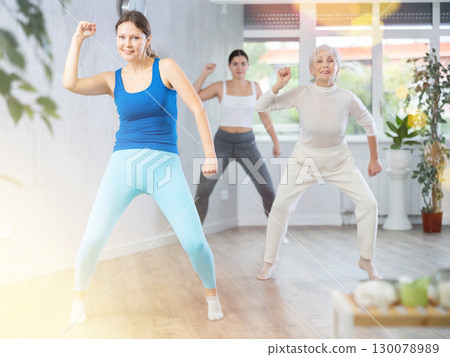 Happy women doing aerobic dances together in dance studio Happy women doing aerobic dances together in dance studio 130078989