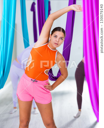 Young girls are warming up before doing aerial yoga Young girls are warming up before doing aerial yoga 130079140