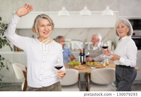 Senior men and women have fun dancing during house party. 130079293