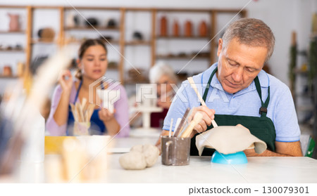 elderly potter is working with clay billet 130079301