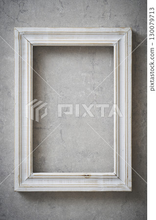 Antique frame hanging on a concrete wall 130079713