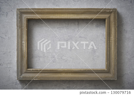 Antique frame hanging on a concrete wall Antique frame hanging on a concrete wall 130079716