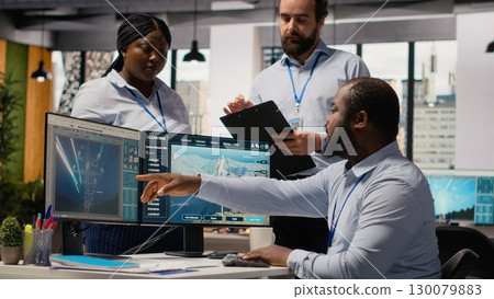 Team of engineers in office doing green energy production technology testing. Teamworking colleagues research cutting edge solutions for biodiversity conservation in renewable energy sector, camera B 130079883