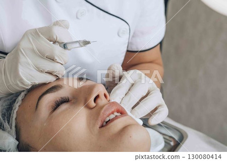 Enhanced Beauty Routine: Expert hands at work in a serene clinic setting 130080414