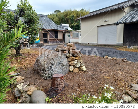 鄉村二手房花園建造過程中堆放的花園石頭和砍伐的樹木，背景是一片竹林 130080578
