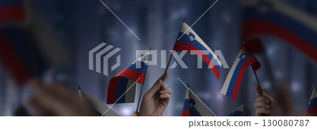 Slovenia flags in their hands on a blurred urban background Slovenia flags in their hands on a blurred urban background 130080787