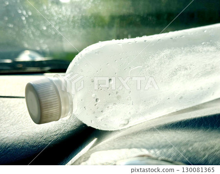 A plastic bottle of cold water on the dashboard of a car A plastic bottle of cold water on the dashboard of a car 130081365