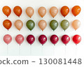 Colorful balloons arranged neatly on a white wall for a festive celebration atmosphere 130081448