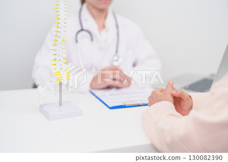 Elderly Patient consulting Doctor with Spine anatomy for Spinal Cord Disorder and disease, Back pain, Lumbar, Sacral pelvis, Cervical neck, Thoracic, Coccyx, Orthopedist, chiropractic, Office Syndrome 130082390