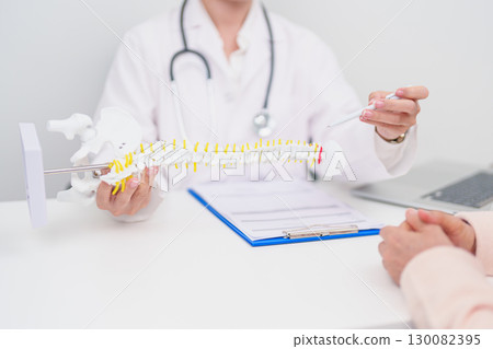 Elderly Patient consulting Doctor with Spine anatomy for Spinal Cord Disorder and disease, Back pain, Lumbar, Sacral pelvis, Cervical neck, Thoracic, Coccyx, Orthopedist, chiropractic, Office Syndrome 130082395