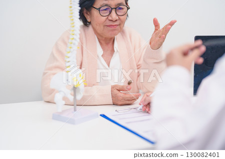 Elderly Patient consulting Doctor with Spine anatomy for Spinal Cord Disorder and disease, Back pain, Lumbar, Sacral pelvis, Cervical neck, Thoracic, Coccyx, Orthopedist, chiropractic, Office Syndrome Elderly Patient consulting Doctor with Spine anatomy for Spinal Cord Disorder and disease, Back pain, Lumbar, Sacral pelvis, Cervical neck, Thoracic, Coccyx, Orthopedist, chiropractic, Office Syndrome 130082401