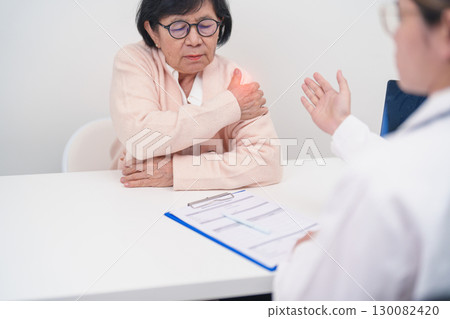 Elderly Woman having Shoulder and Neck and consulting doctor in hospital. Muscle painful due to Myofascial pain syndrome and Fibromyalgia, rheumatism, Scapular pain, Cervical Spine. ergonomic concept Elderly Woman having Shoulder and Neck and consulting doctor in hospital. Muscle painful due to Myofascial pain syndrome and Fibromyalgia, rheumatism, Scapular pain, Cervical Spine. ergonomic concept 130082420