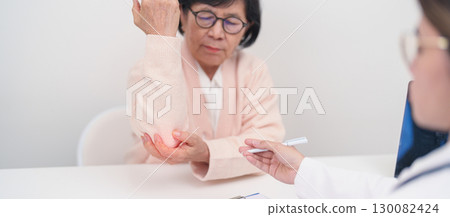 Elderly Woman having elbow ache and consulting doctor in hospital. muscle pain due to lateral epicondylitis or tennis elbow. injury, Health and medical consultation concept Elderly Woman having elbow ache and consulting doctor in hospital. muscle pain due to lateral epicondylitis or tennis elbow. injury, Health and medical consultation concept 130082424